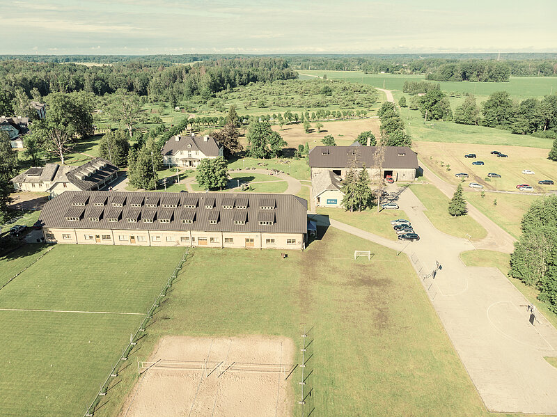 [Translate to Angļu:] Kompleksa "Ratnieki" teritorijas skats no augšas ar esošajiem sporta laukumiem